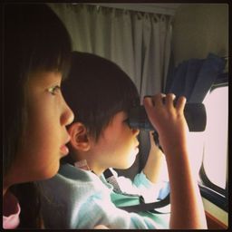 Jairus and Kristen , in their pj's , at the window of our campervan looking out at ....